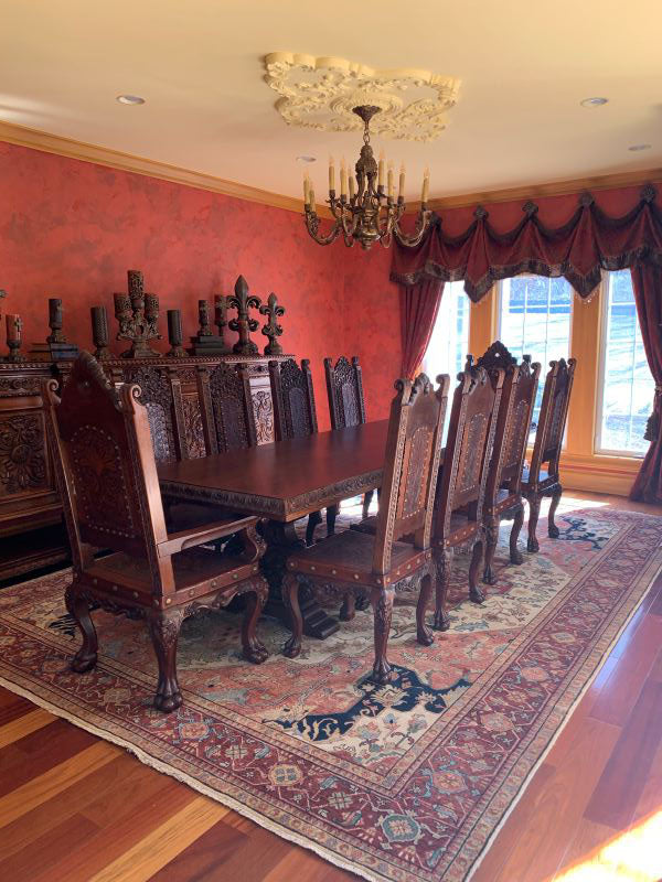 Italian Revival Dining room with ornate wooden furniture and red walls.